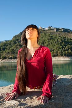 Woman at morning yoga exercises in scenic outdoor setting