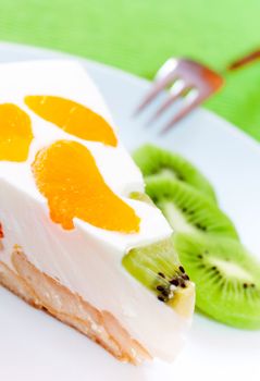 A delicious cake with clementine and kiwi on a bed of biscuits