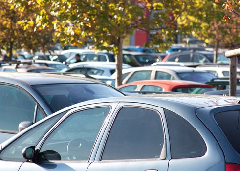 Supermarket car park full of cars, evocation of overconsumption