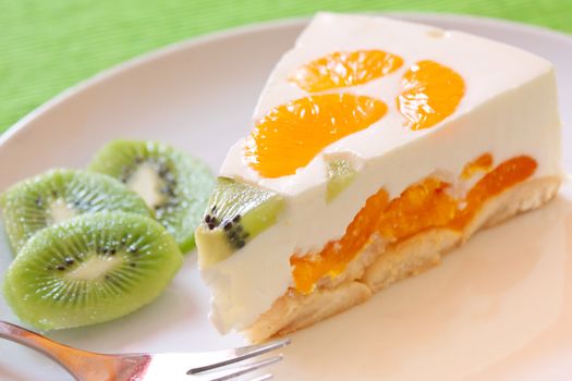 A delicious cake with clementine and kiwi on a bed of biscuits