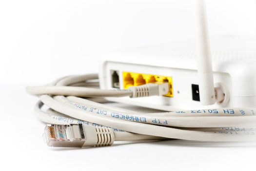 A router in top of an ethernet cable. Focus on the plug not connected.