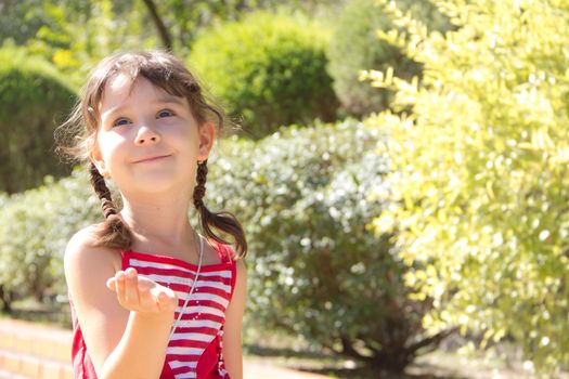 beautiful little girl sends an air kiss and smiling