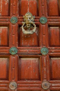 Detail of an ornate door knocker on the door of a building