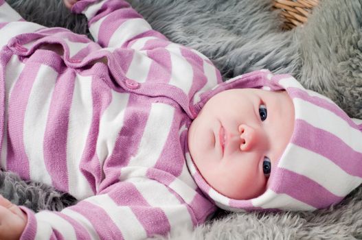 Shot of little cute baby in stripped clothes