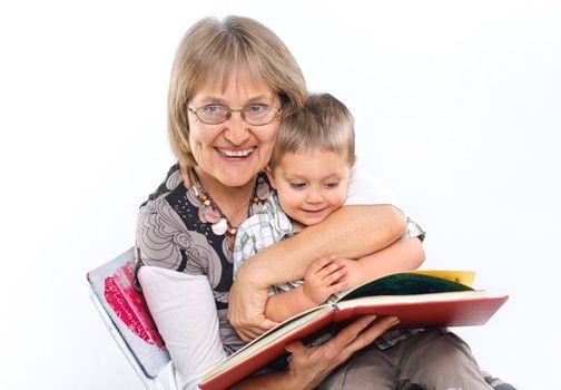 Grandmother and grandson reading a book together. Symbol of the family.