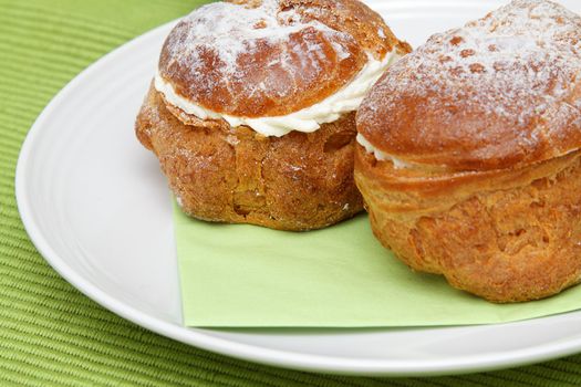 Photo of two profiteroles on white plate