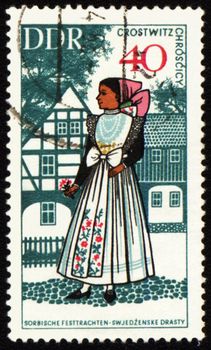 GDR - CIRCA 1960s: stamp printed in GDR (East Germany), shows young woman in national costume, circa 1960s