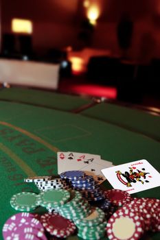 green casino table with chips and four aces in a poker game and a joker in the pack