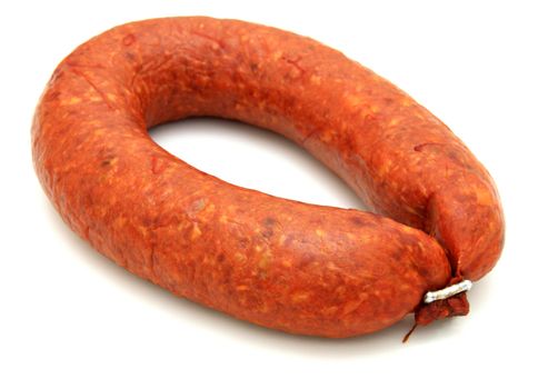 Tasty sausage is curtailed by a ring lies on a white background