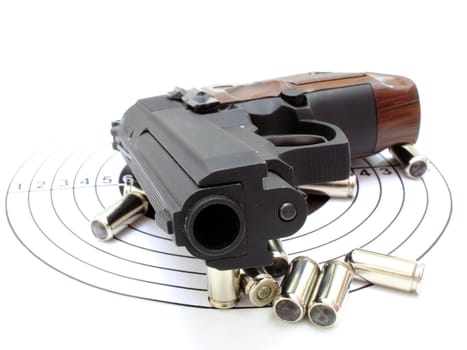 The pistol with the brown handle with a target and cartridges lies on a white background
