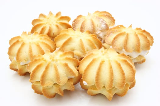 Yellow cookies with a white stuffing lie on a white background in the form of a circle