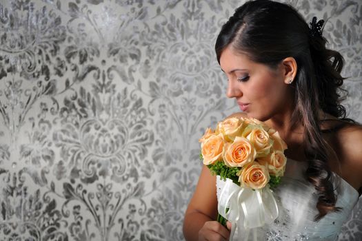 A lovely bride looks down at her bouquet.