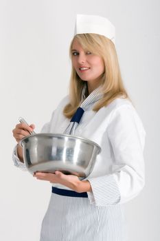 Female baker with a bowl and whisk to stir the dough