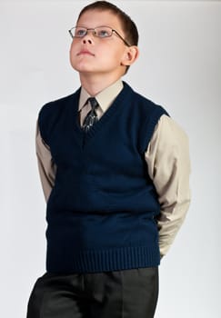 Schoolboy. Isolated over white background. The boy is dressed in a vest.