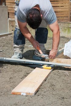 Mason preparing formwork in wood to build a terrace