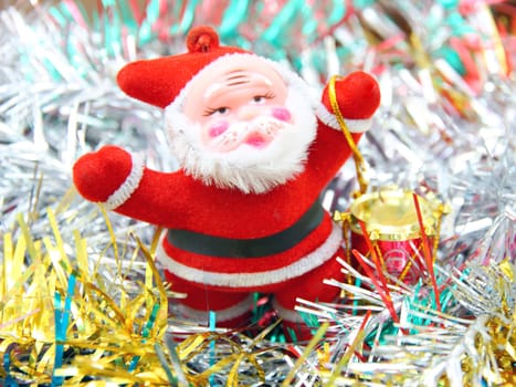 Doll of Santa Claus with a red drum against a tinsel