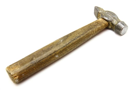 The old metal hammer with the wooden handle lies on a white background