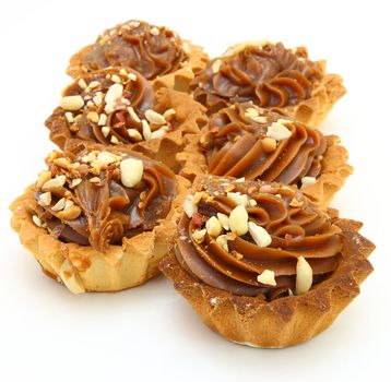Pie a basket with chocolate condensed milk and nuts on a white background