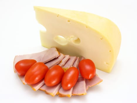 Cheese with holes and red tomatoes lie on a white background