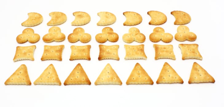 Salty crackers of the various geometrical form lie on a white background