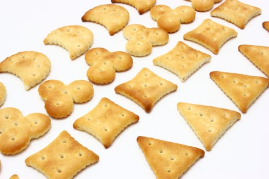 Salty crackers of the various geometrical form lie on a white background