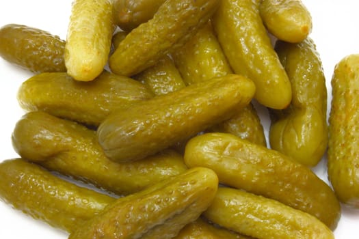 Green tasty pickles lie on a white background a small group