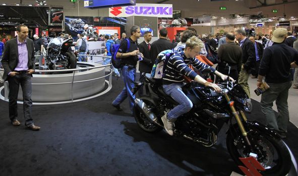 Looking at Suzuki motorcycles in exhibition at EICMA, International Motorcycle Exhibition in Milan, Italy.