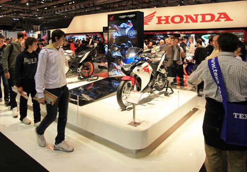 People trough Honda motorcycles exhibition area at EICMA, International Motorcycle Exhibition in Milan, Italy.