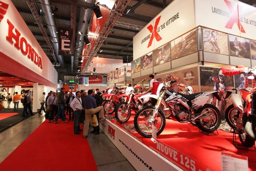 Looking at products and brand new motorcycles during EICMA, International Motorcycle Exhibition in Milan, Italy.