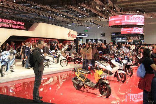 Looking at products and brand new motorcycles during EICMA, International Motorcycle Exhibition in Milan, Italy.