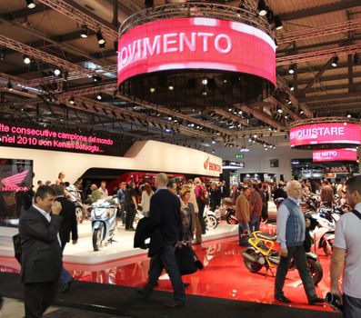 Looking at products and brand new motorcycles during EICMA, International Motorcycle Exhibition in Milan, Italy.