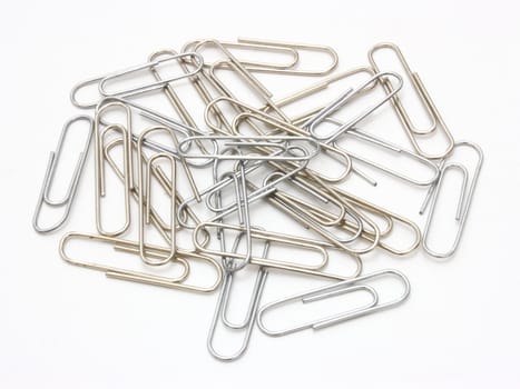 Writing metal paper clips lie in bulk on a white background of a paper