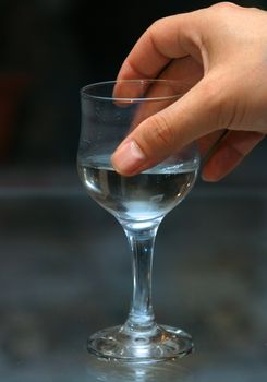 Glass with alcohol in a man's hand