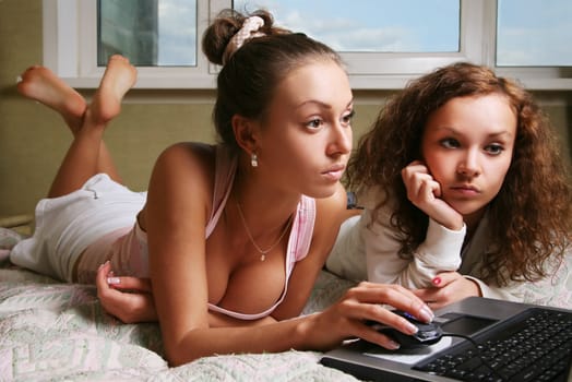 Two young girls of a house with laptop