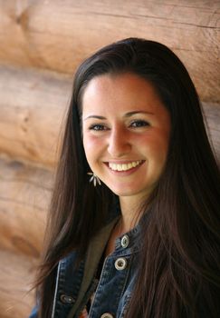 Smiling girl on a background of a wooden wall