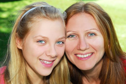 Portrait of a smiling mother and teenage daughter in summer park