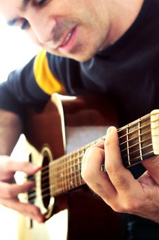 Man playing a musical instrument accoustic guitar