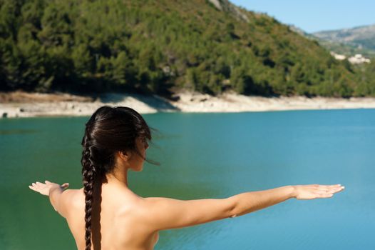 Woman enjoying early morning yoga on the shores of a lake