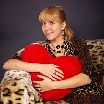 Portrait of a beautiful young woman with a toy heart in his hands