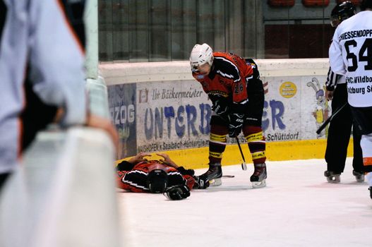 ZELL AM SEE, AUSTRIA - MARCH 19: Salzburg hockey League. Injured Schuettdorf player after hard hit. Game SV Schuettdorf vs Salzburg Sued  (Result 10-4) on March 19, 2011, at the hockey rink of Zell am See.