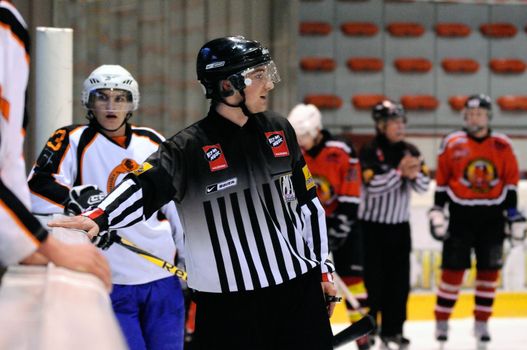 ZELL AM SEE, AUSTRIA - MARCH 19: Salzburg hockey League. Linesman trying to calm down benches after fight. Game SV Schuettdorf vs Salzburg Sued  (Result 10-4) on March 19, 2011, at the hockey rink of Zell am See.