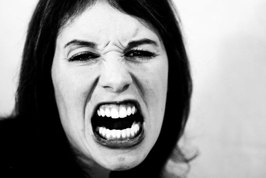 Black and white shot of mad, screaming woman.