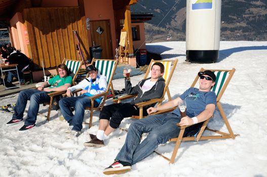 KAPRUN AUSTRIA - MARCH 5: Maiskogel Fanlauf 2011. Men relaxing in canvas chair
 at charity ski race with many celebrities in austria on March 5, 2011 at the Maiskogel in Kaprun, Austria