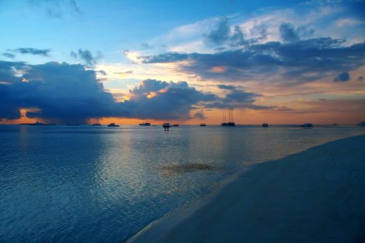 Evening pictures of the beach and boats on Meeru Island, Maldives