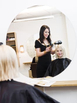 Hairdresser in action with blond customer