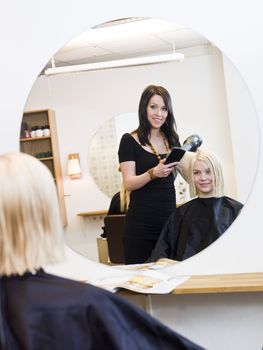 Hairdresser in action with blond customer