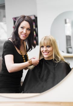 Hairdresser in action with blond customer