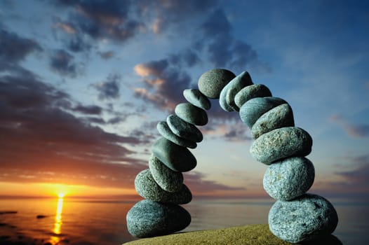 Arc of the pebbles on the seashore, in evening