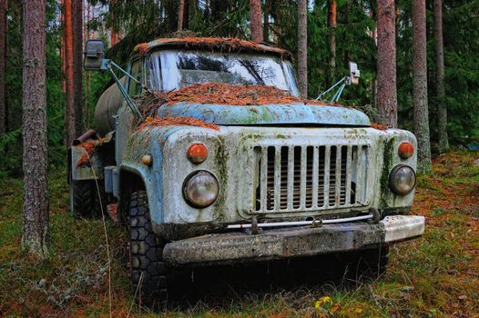 Old tank truck in the coniferous forest