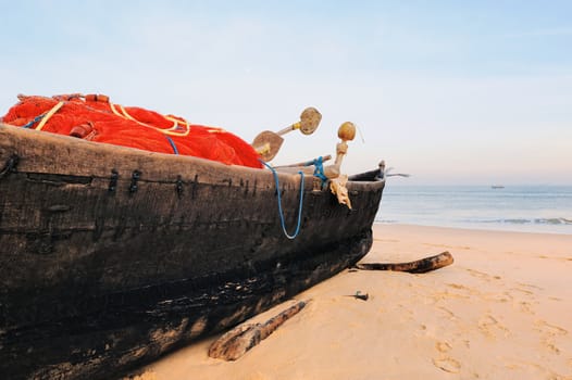 Old fishing boat on the sandy beach in Goa
